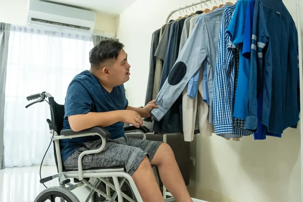 Disabled man in wheelchair choosing clothing from a rack